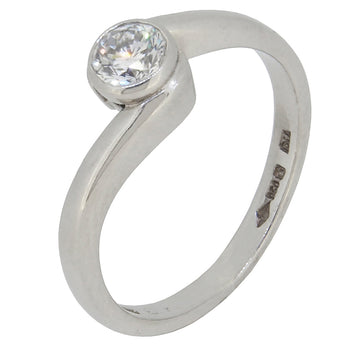 A modern, platinum, diamond set, single stone, solitaire crossover ring.