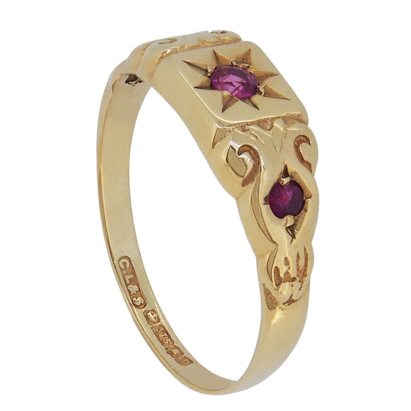 A modern, 9ct yellow gold, ruby, star set, three stone ring