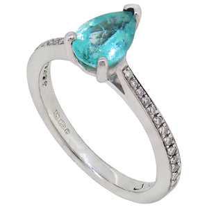 A modern, platinum, paraiba tourmaline set ring with diamond set shoulders.