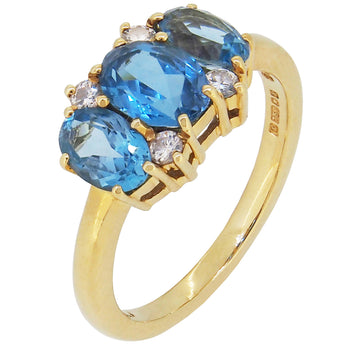 A modern, 18ct yellow gold, blue topaz & diamond set seven stone ring.