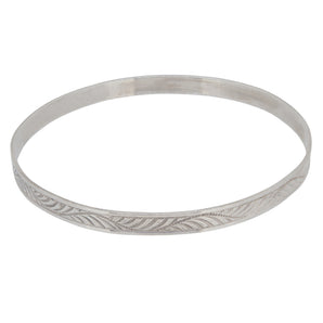 A mid-20th century, white metal, flat bangle with an engraved foliate design.