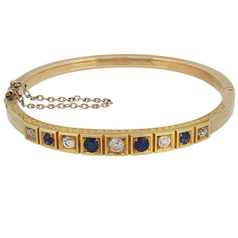 A Victorian, 18ct yellow gold, sapphire & diamond set, nine stone, hinged bangle.