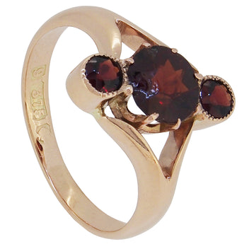 A mid-20th century, 9ct rose gold, garnet set three stone crossover ring.