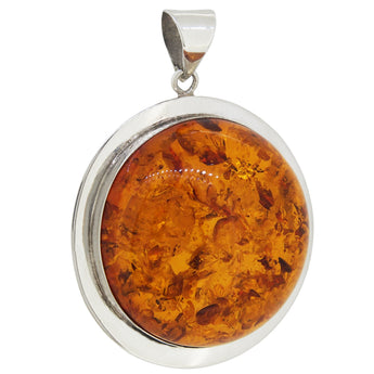 A modern, silver, amber set, circular pendant.