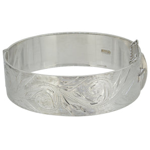 A modern, silver, flat hinged bangle with an engraved foliate design.