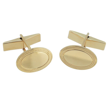 A pair of modern, 9ct yellow gold, oval swivel link cufflinks with an engine turned border.