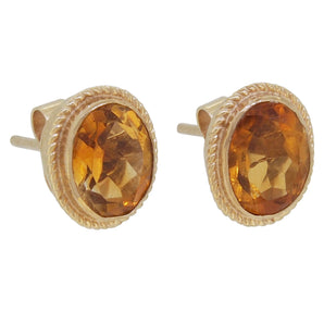 A pair of modern, 9ct yellow gold, citrine set stud earrings with a cord border.