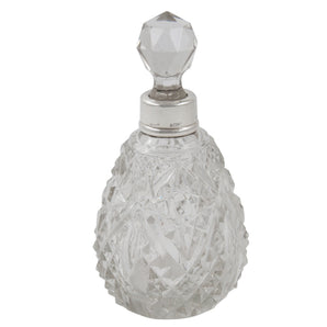 An Edwardian, cut glass scent bottle with a silver mount & faceted glass stopper.