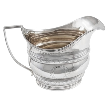 A Georgian, silver cream jug with a silver gilt interior