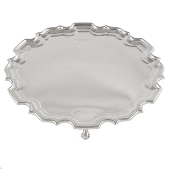 An Edwardian, silver, circular card tray, with a raised piecrust edge, standing on three feet.