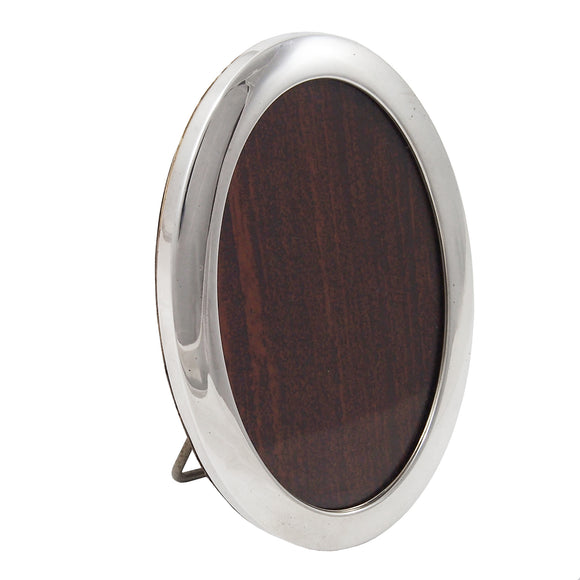 A white metal, oval photograph frame