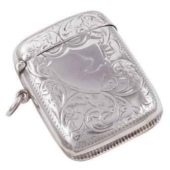 A Victorian, silver vesta case with a vacant shield cartouche & floral decorations front & back.