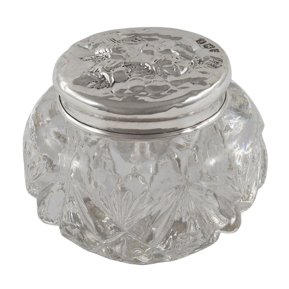 An Edwardian, glass jar with a silver lid embossed with images of cherubs