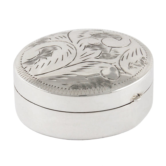 A modern, silver, circular pill box