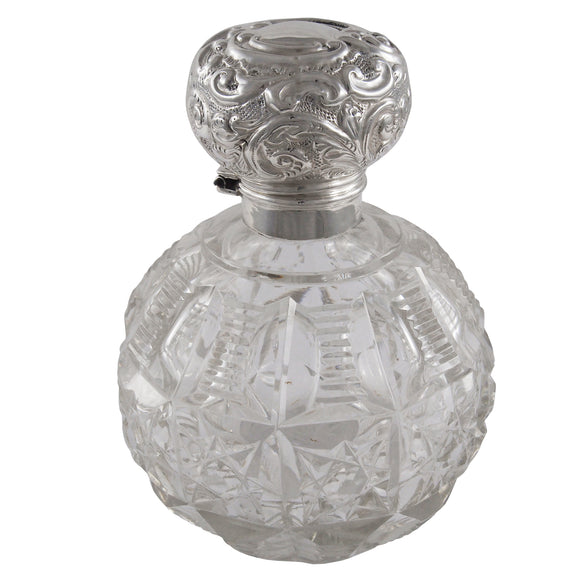 An Edwardian, cut glass perfume bottle with a glass stopper & silver lid