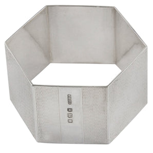 A mid-20th century, silver hexagonal napkin ring with engine turned decoration.