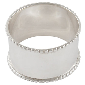 A modern, silver napkin ring with a bead edge.