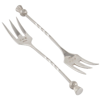 A pair of early 20th century, silver forks with thistle decorations on the terminal ends.