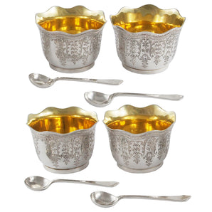A set of four Victorian, silver, engraved open salts with fluted edges, gilt interiors & four silver spoons.
