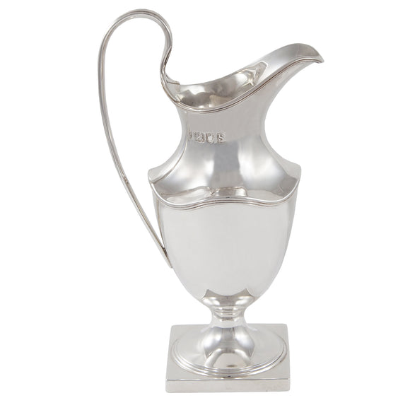 An Edwardian, silver cream jug on a square base.