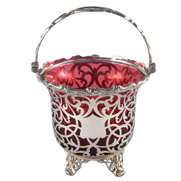 A Victorian, silver, circular, pierced sugar basket, with a cranberry coloured glass liner.