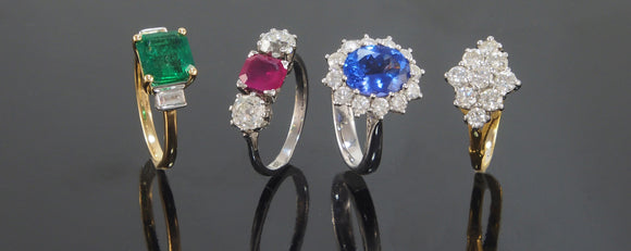 An emerald & diamond set ring, a ruby & diamond set ring, a sapphire & diamond set ring & a diamond set ring