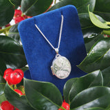 A modern, silver, engraved, oval locket &amp; chain.