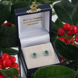 A pair of modern, 18ct white gold, emerald & diamond set stud earrings.