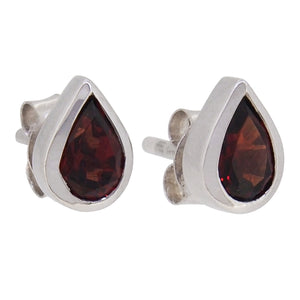 A pair of modern, silver, garnet set stud earrings