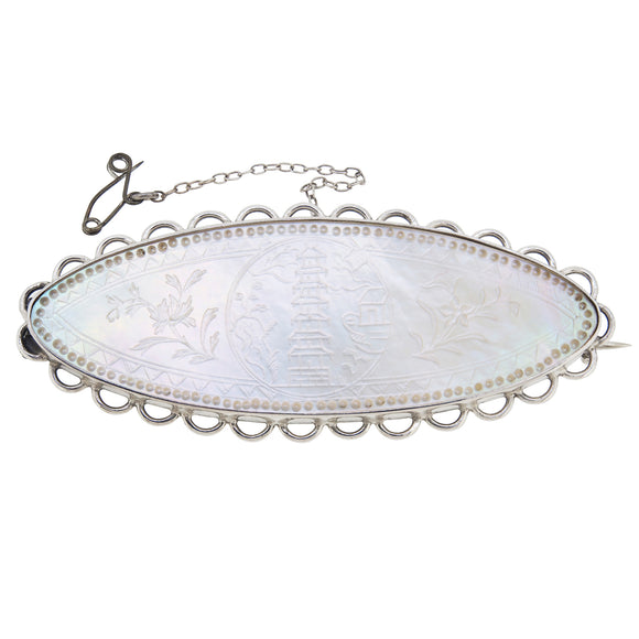 A modern, silver, mother of pearl set brooch featuring images from Kew Gardens