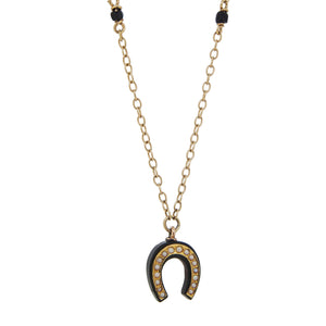 A yellow gold, black onyx & seed pearl set horseshoe necklace.