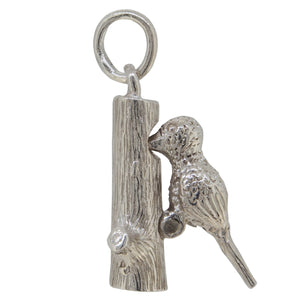 A silver, woodpecker charm pendant