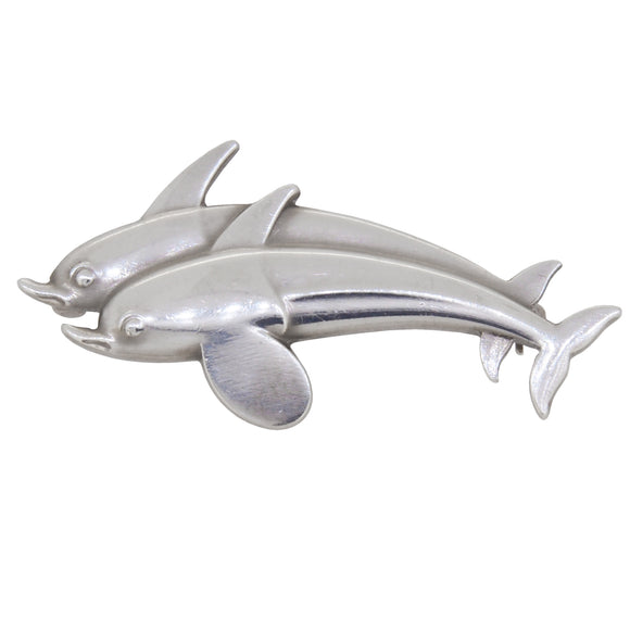 A modern, silver, double dolphin brooch