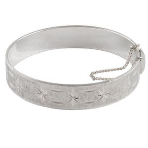 A mid-20th century, silver, diamond cut, hinged bangle