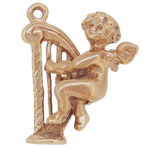 A mid-20th century, 9ct yellow gold, cherub &amp; harp charm