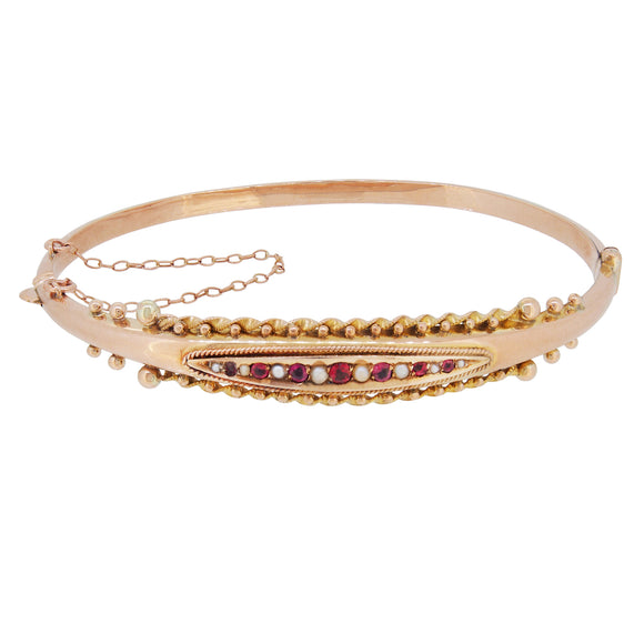 An Edwardian, 9ct yellow gold, ruby & pearl set bangle