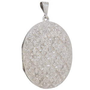 A Victorian, silver, oval locket with a floral decoration