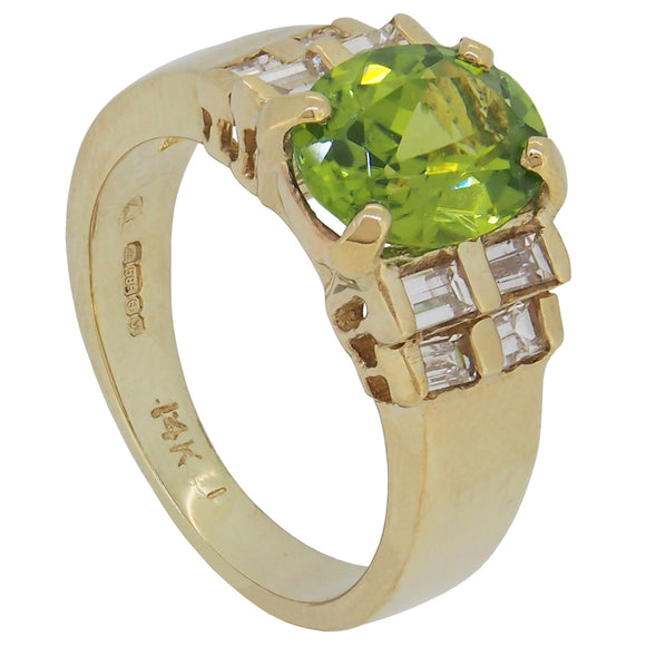 A modern, 14ct yellow gold, peridot & baguette cut diamond set, nine stone ring