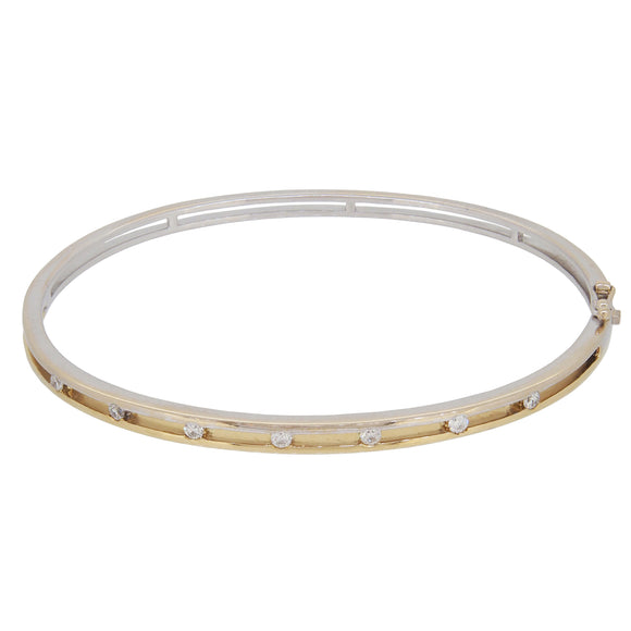 A modern, 18ct white & yellow gold, diamond set, seven stone hinged bangle