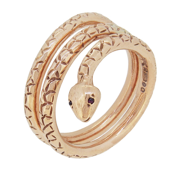 A modern, 9ct yellow gold, coiled snake ring with garnet set eyes