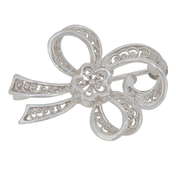A modern, silver, filigree bow brooch