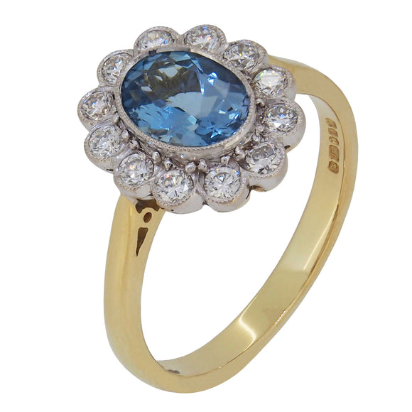 A modern, 18ct yellow & white gold, aquamarine & diamond set cluster ring.