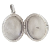 A modern, silver, abalone set circular locket