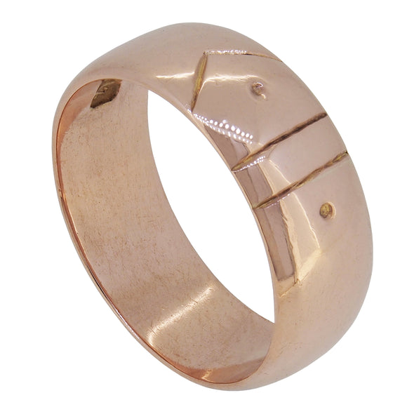 An early 20th century, 9ct rose gold, D shaped wedding ring with a buckle design engraving