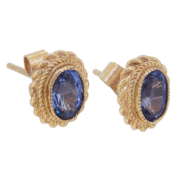 A pair of modern, 9ct yellow gold, aquamarine set stud earrings with a cord border.