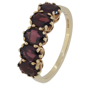 A modern, 9ct yellow gold, garnet set, five stone half hoop ring.