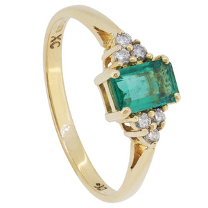 A modern, 18ct yellow gold, emerald &amp; diamond set, seven stone ring.