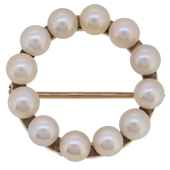 A modern, 9ct yellow gold, pearl set circular brooch.