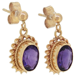 A pair of modern, amethyst set drop earrings with a cord border.