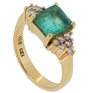 A modern, yellow gold, emerald & diamond set cluster ring